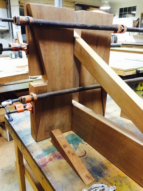 Wooden furniture being assembled with clamps in a workshop.