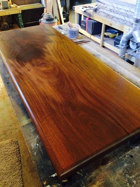Wooden table top with a glossy finish in a woodworking shop.