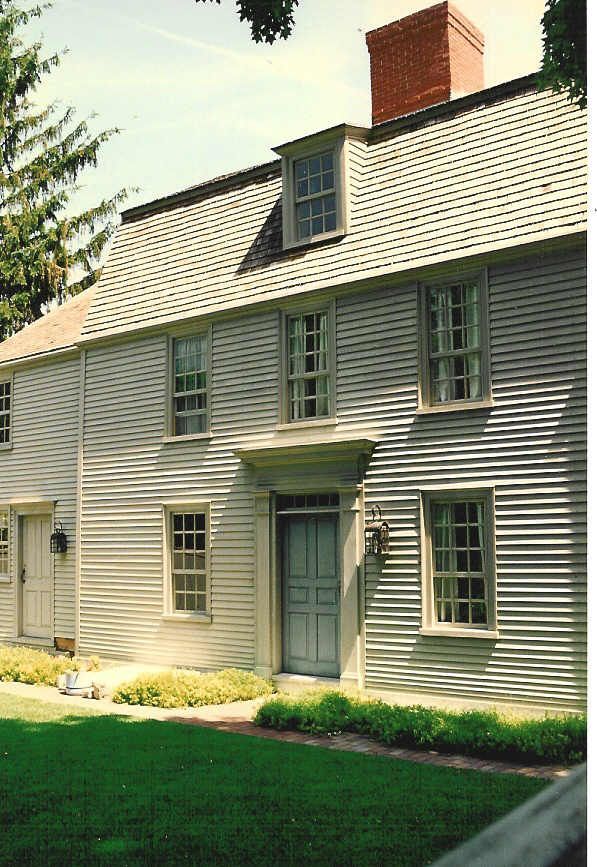 A large white house with a brick chimney on the roof