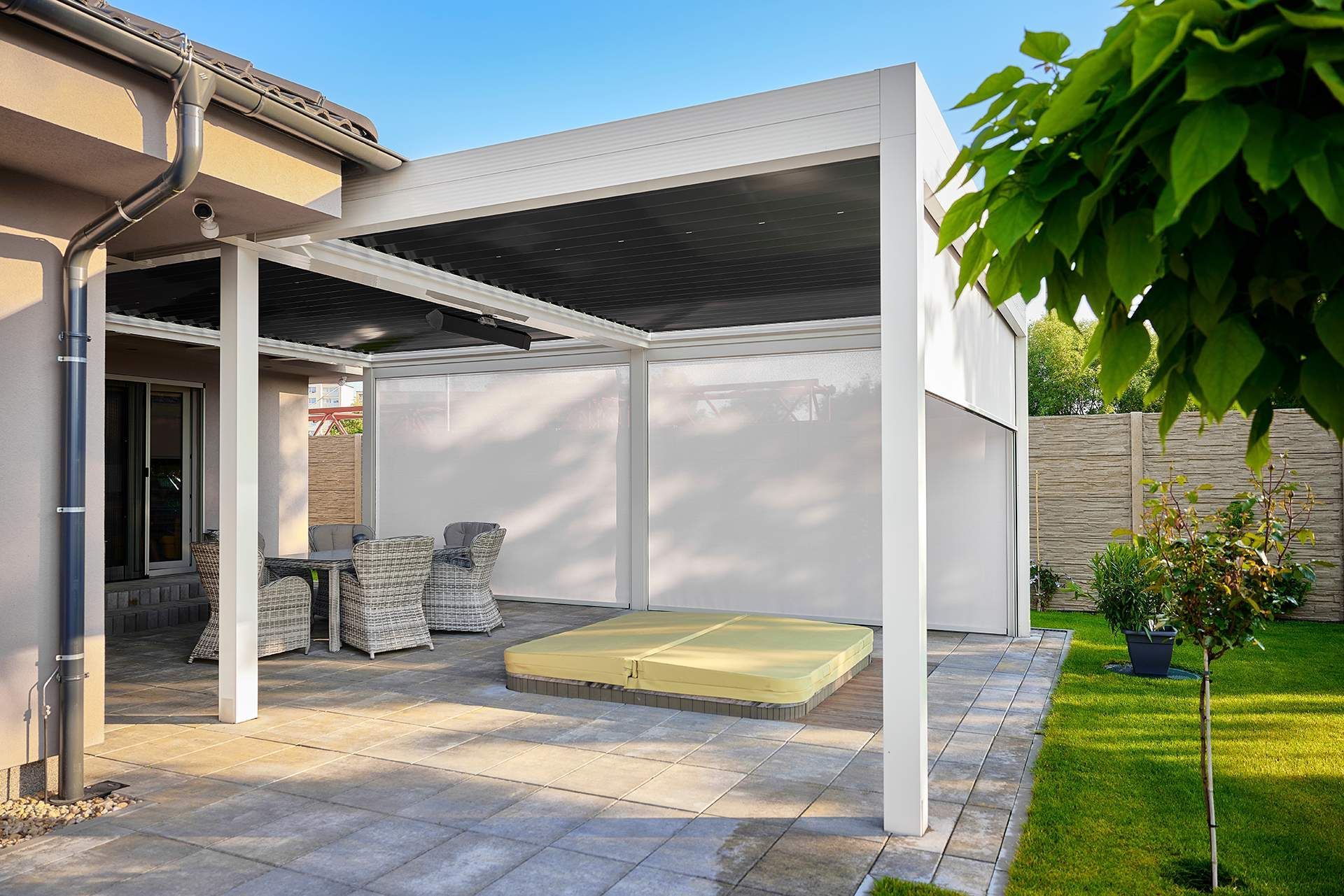 A white pergola is sitting in the backyard of a house.