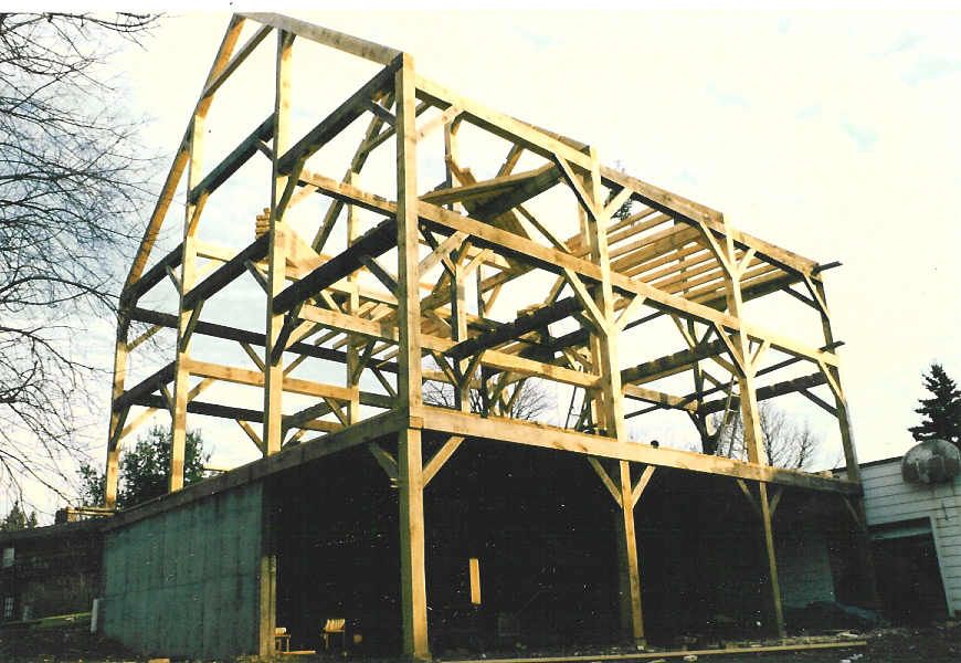 A large wooden structure is being built in the countryside