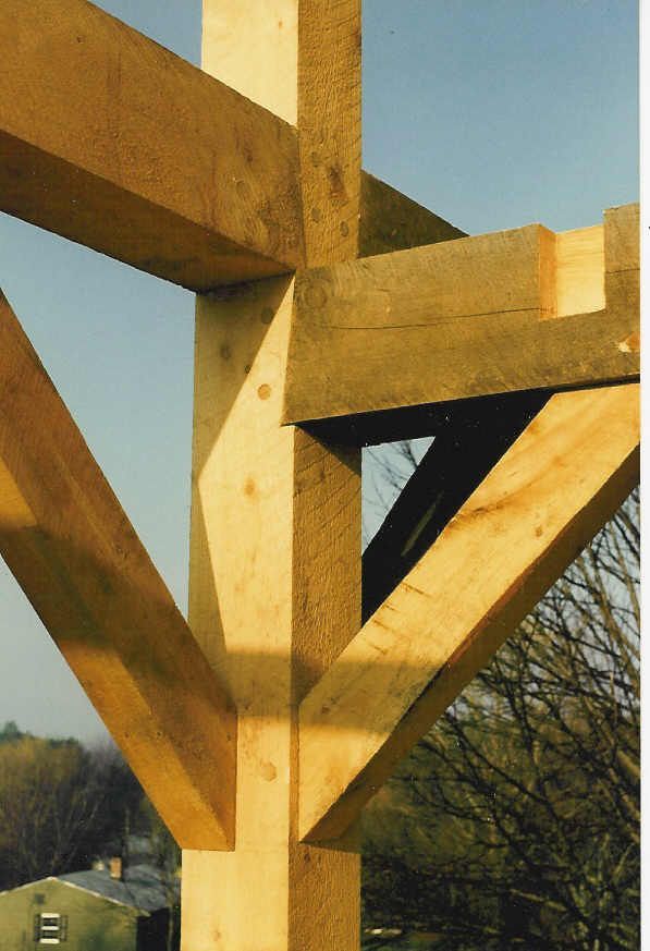 A close up of a wooden structure with a house in the background