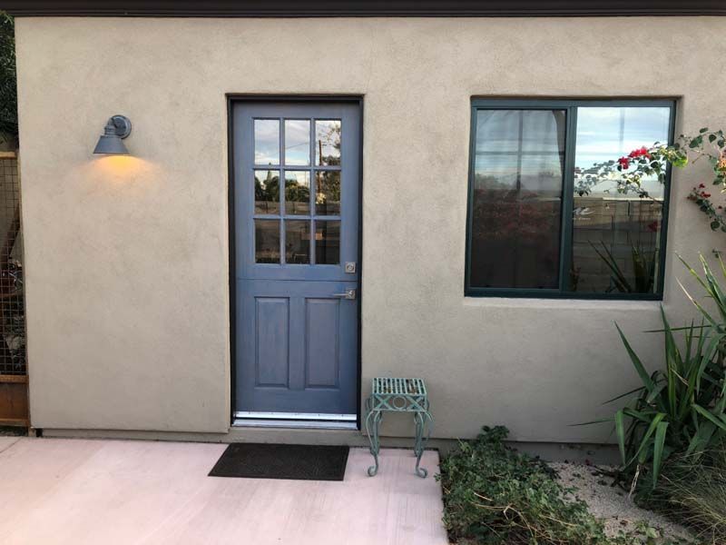 A small house with a blue door and a window