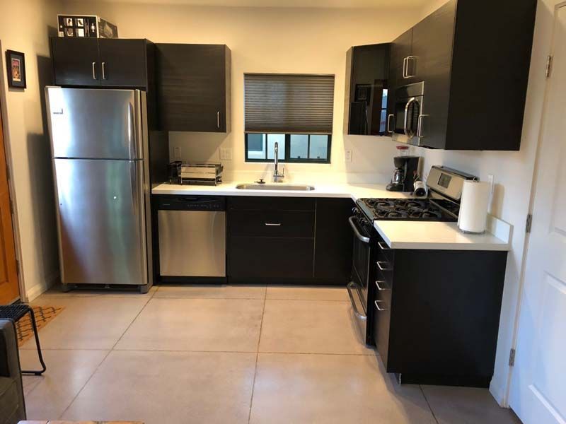 A kitchen with stainless steel appliances and black cabinets