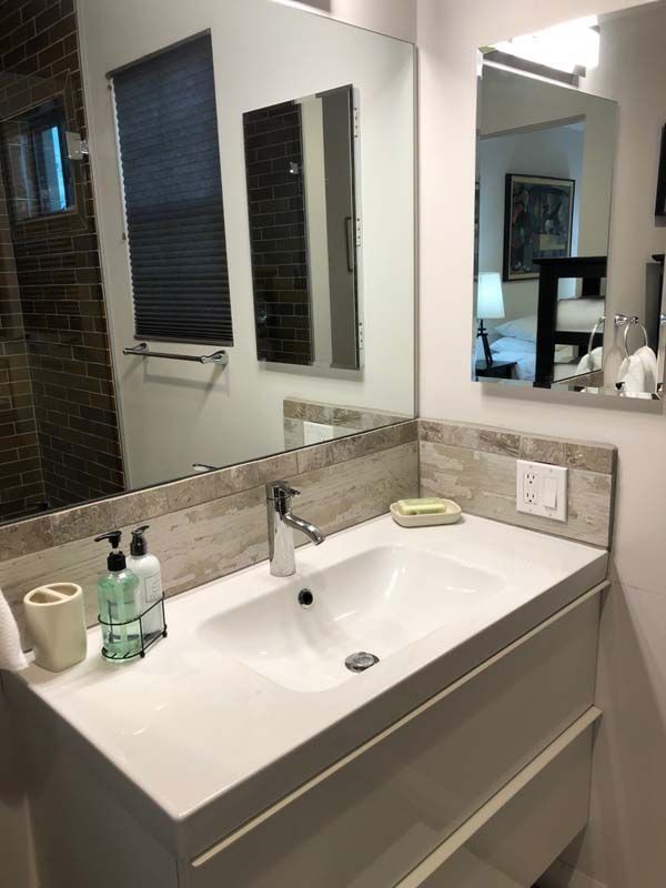 A bathroom with a sink , mirror and shower.