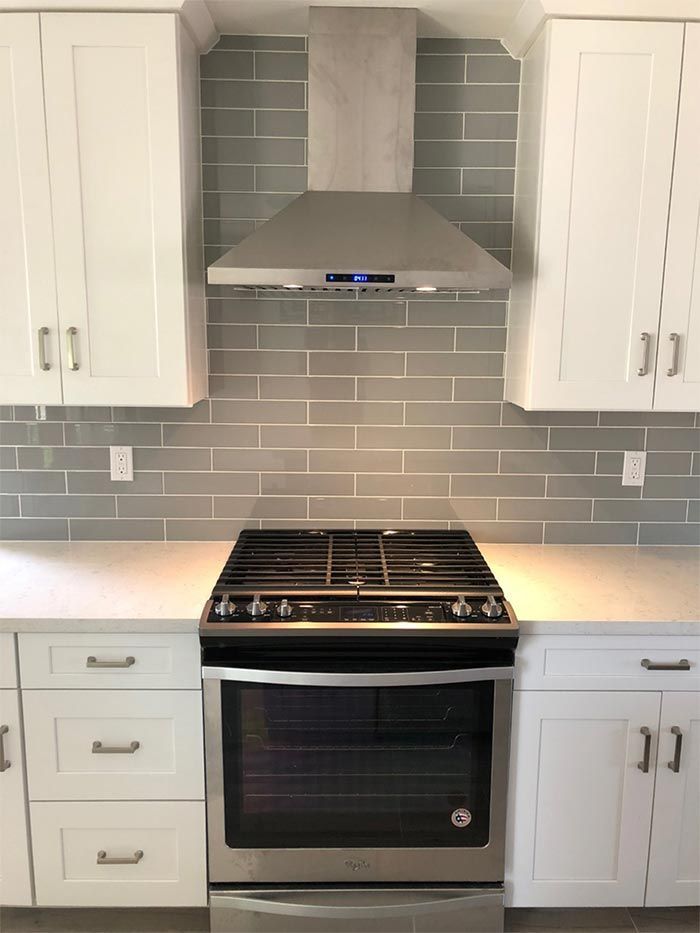 A kitchen with stainless steel appliances and white cabinets