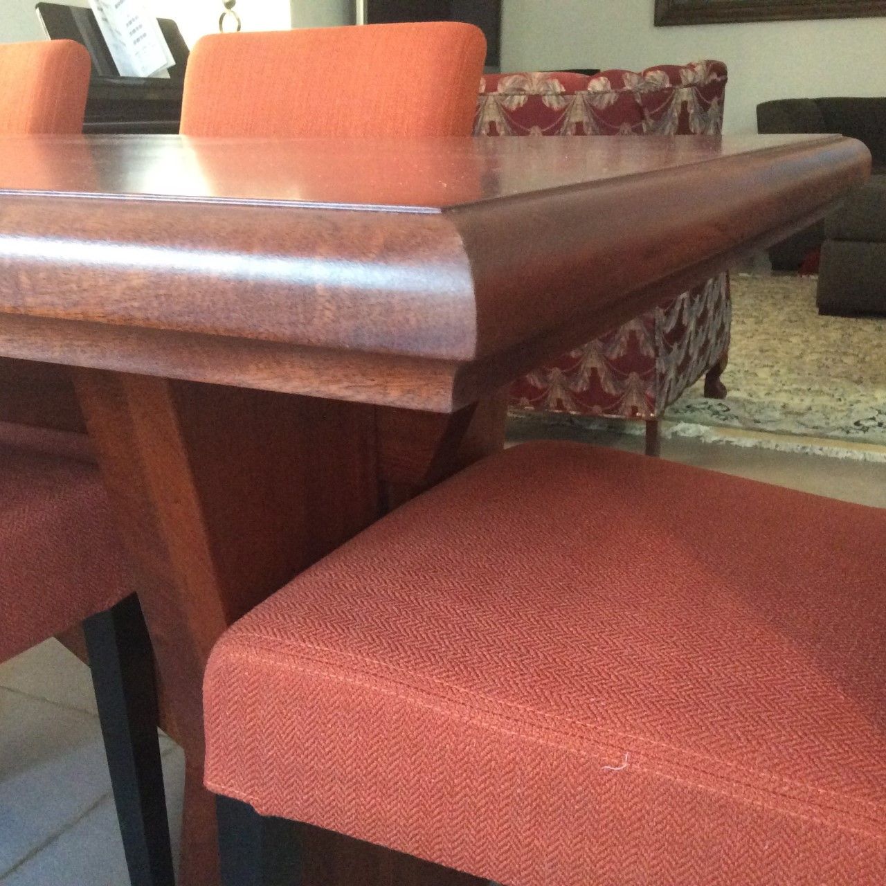 A wooden table with orange chairs in a living room