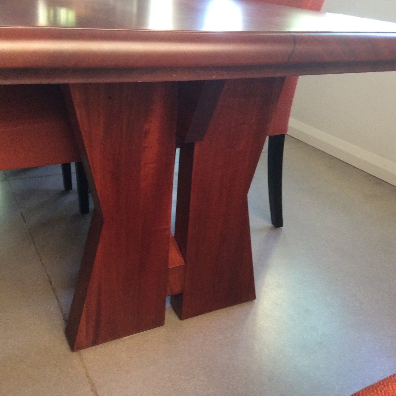A wooden table with two chairs underneath it