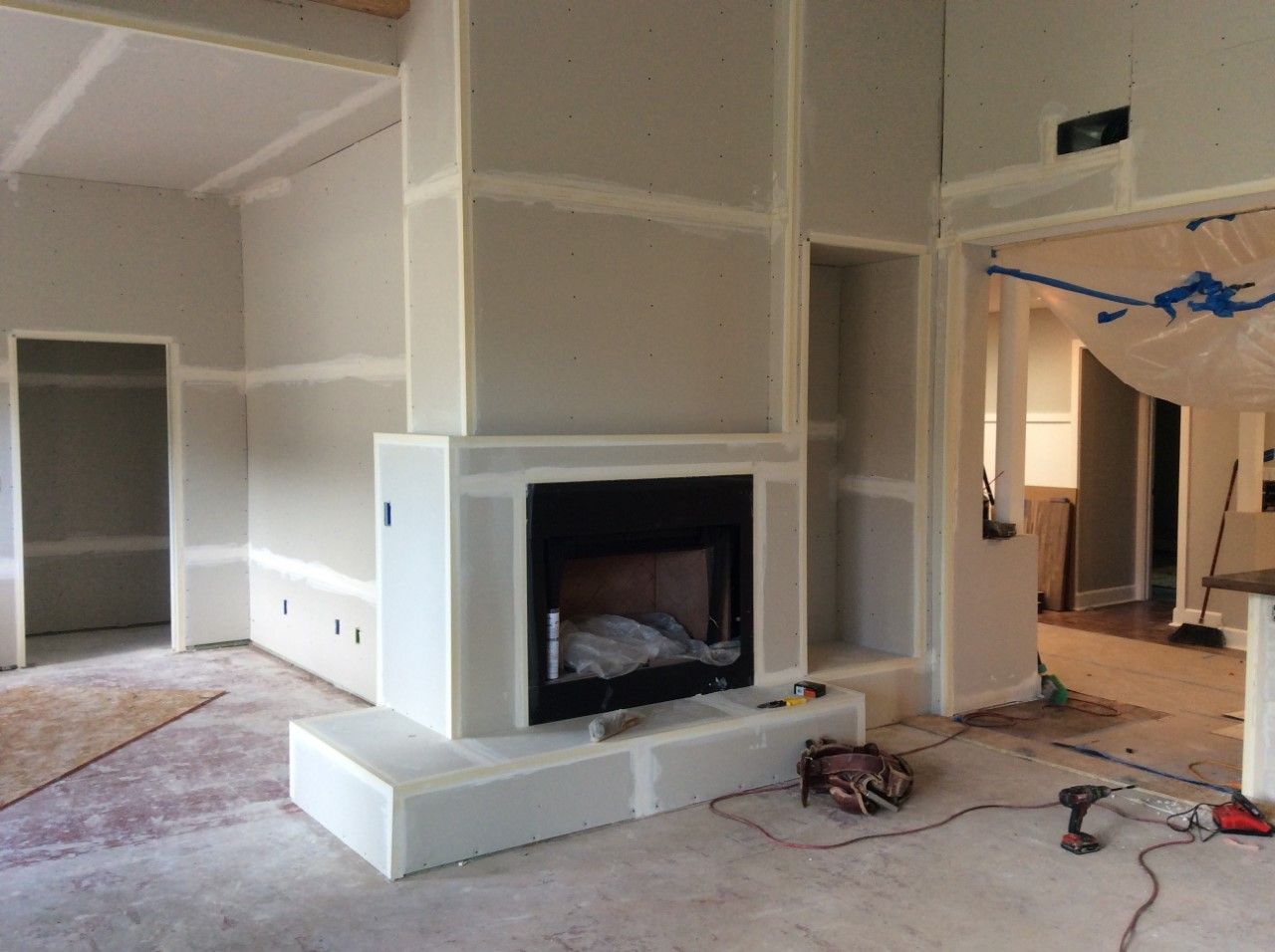 A living room with a fireplace and a drill on the floor