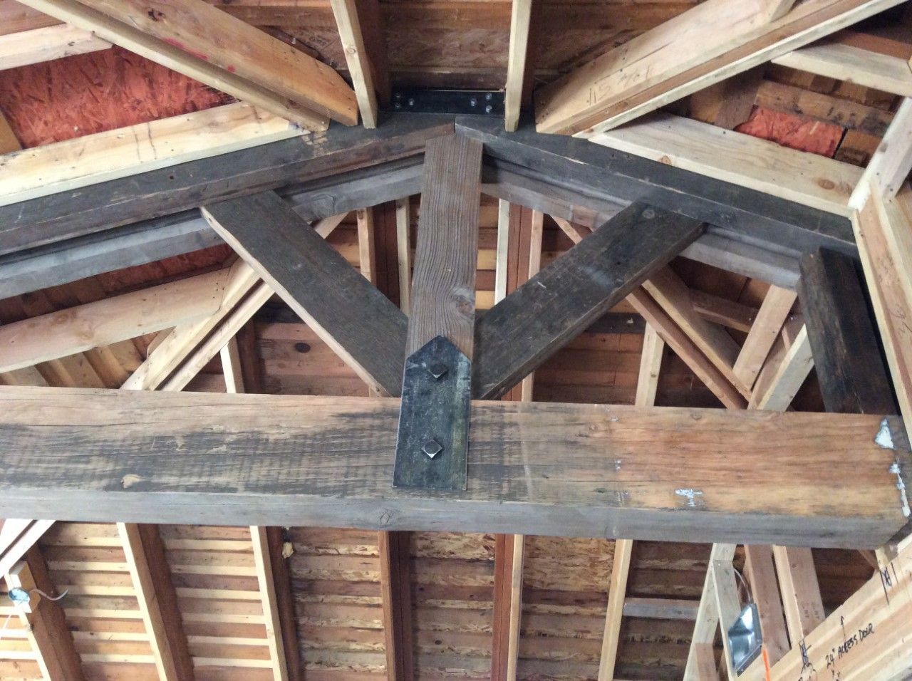 The ceiling of a building is made of wood and metal.