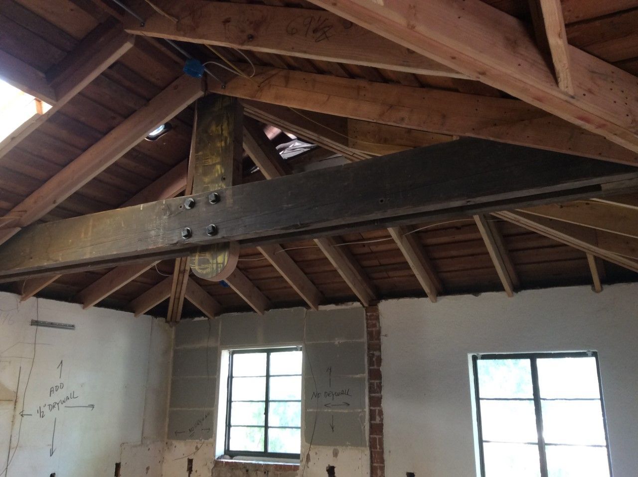 A room with a wooden ceiling and a few windows