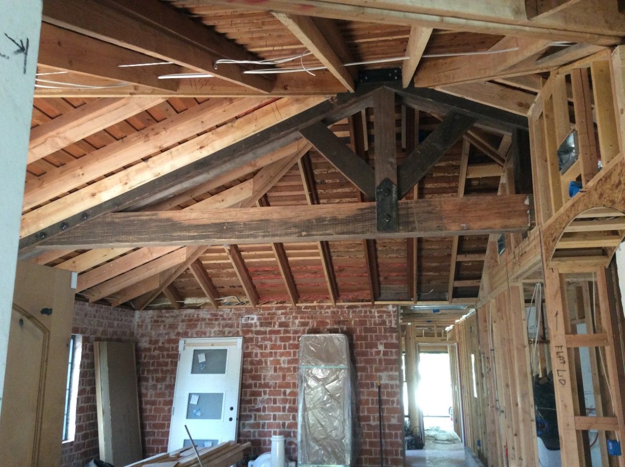The inside of a house under construction with wooden beams and brick walls