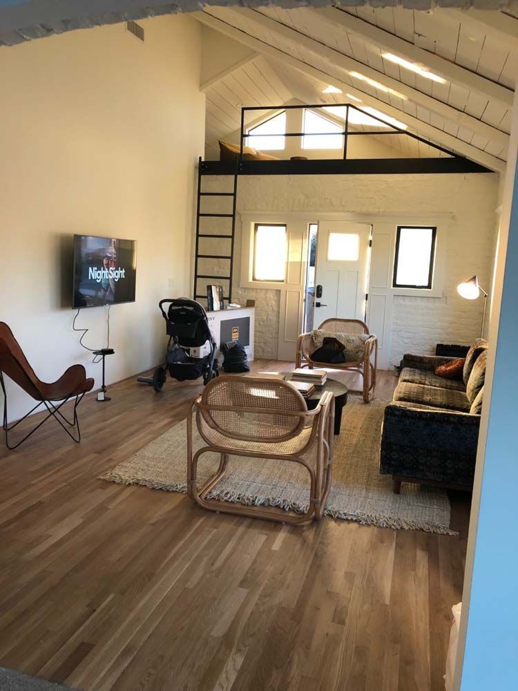 A living room with a couch , chairs , and a flat screen tv.