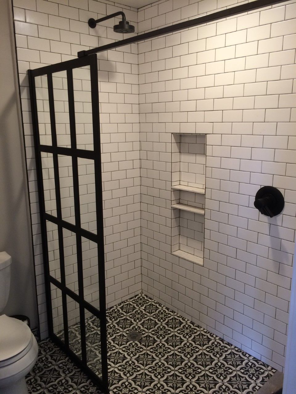 A bathroom with a walk in shower and a toilet