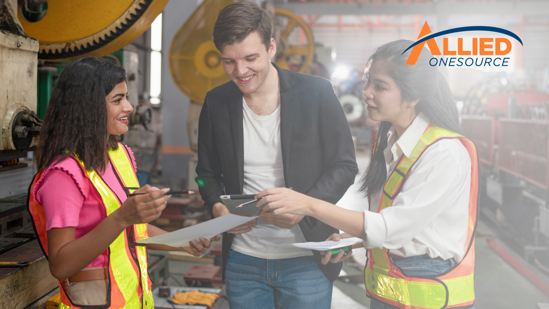 Warehouse team reviewing light industrial salary trends reports in manufacturing facility setting