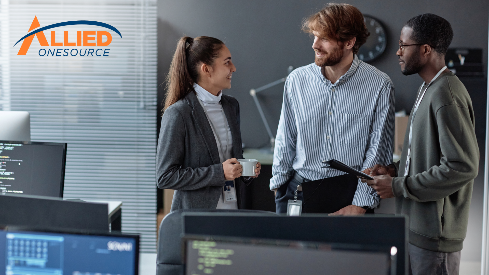 Three IT professionals collaborate in a modern office, illustrating workforce insights from Allied O
