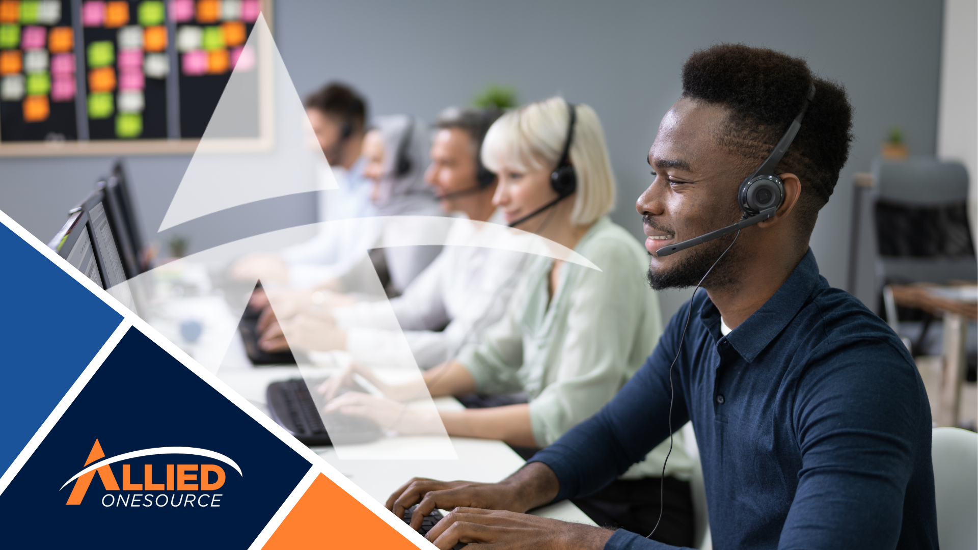 A team of call center employees wearing headsets works at computer stations in an office, focusing o
