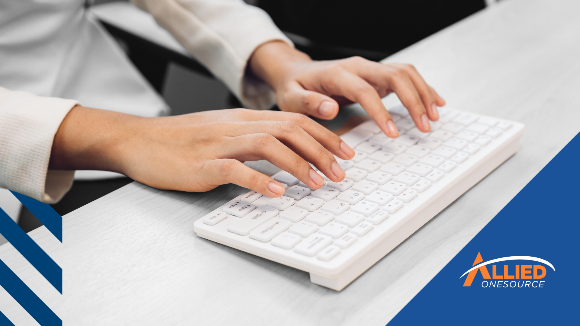 A person typing on a white computer keyboard. 