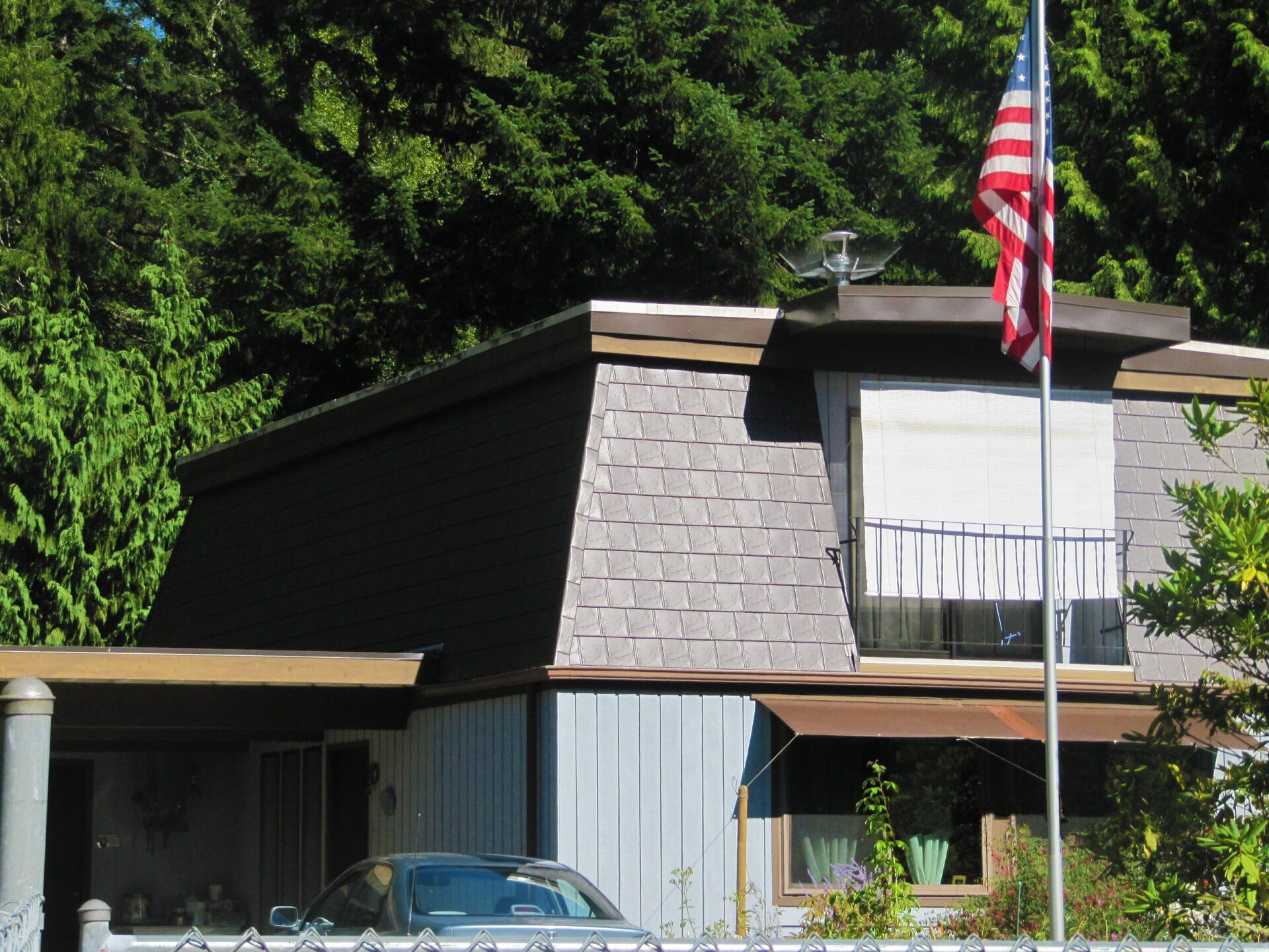 An american flag is flying in front of a house
