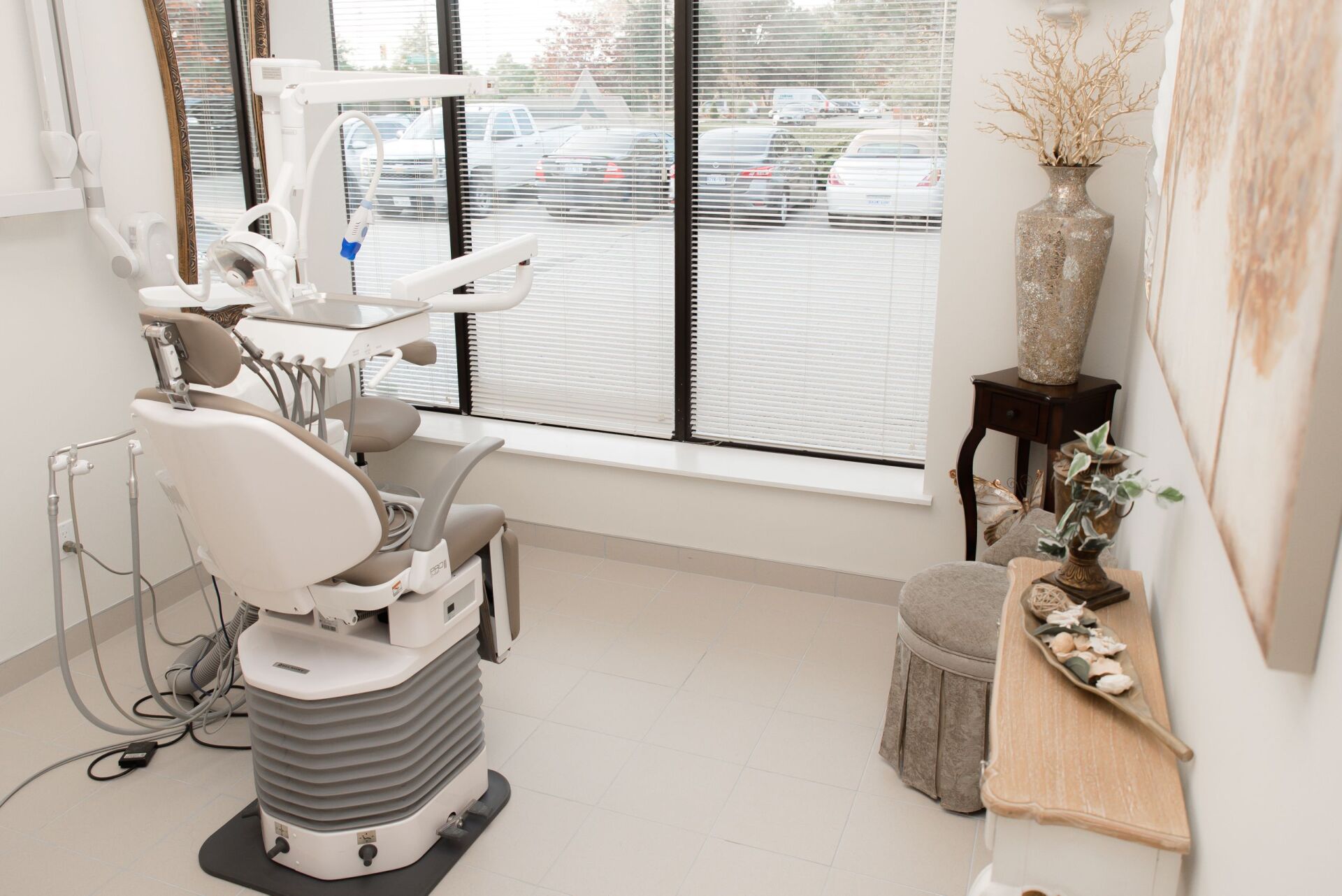 A dental office with a dental chair and a window.