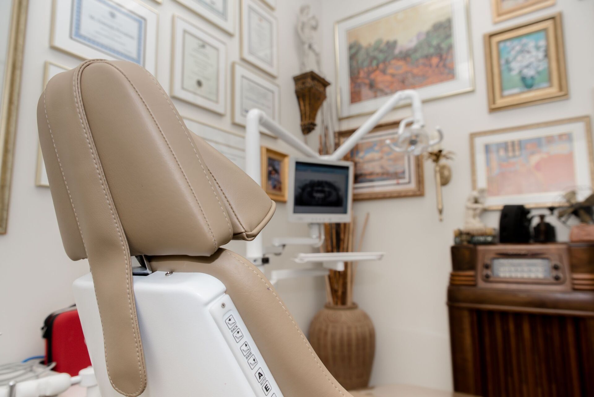 A dental office with a dental chair and a monitor