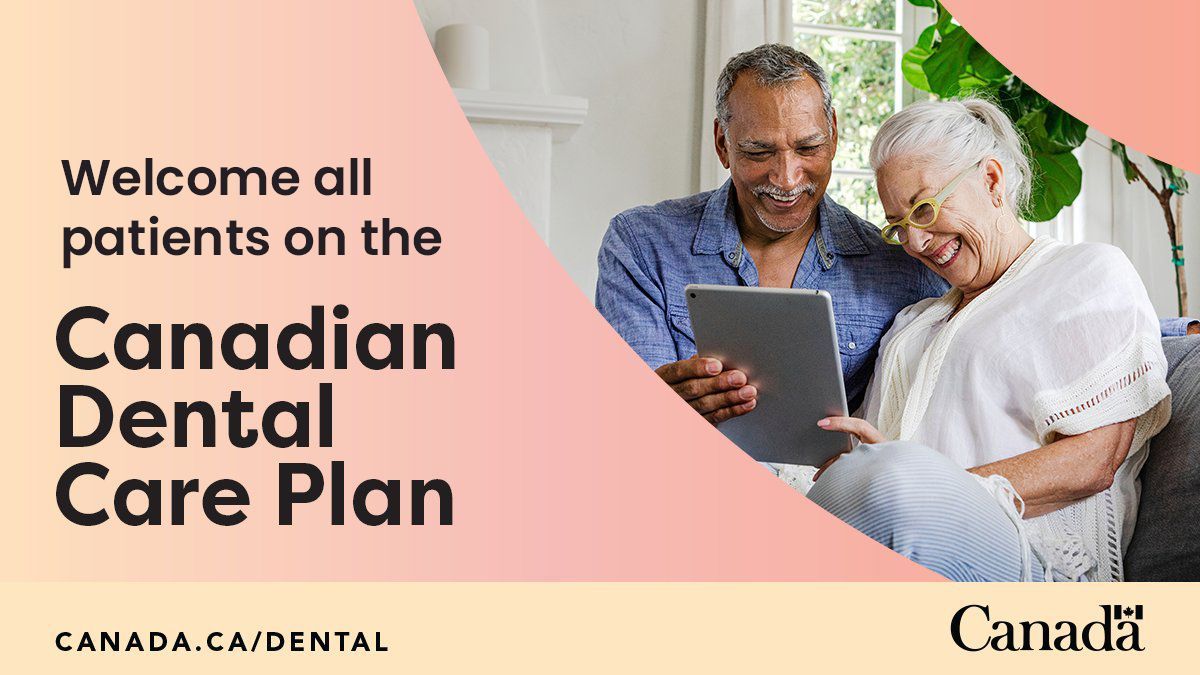 A man and a woman are sitting on a couch looking at a tablet.