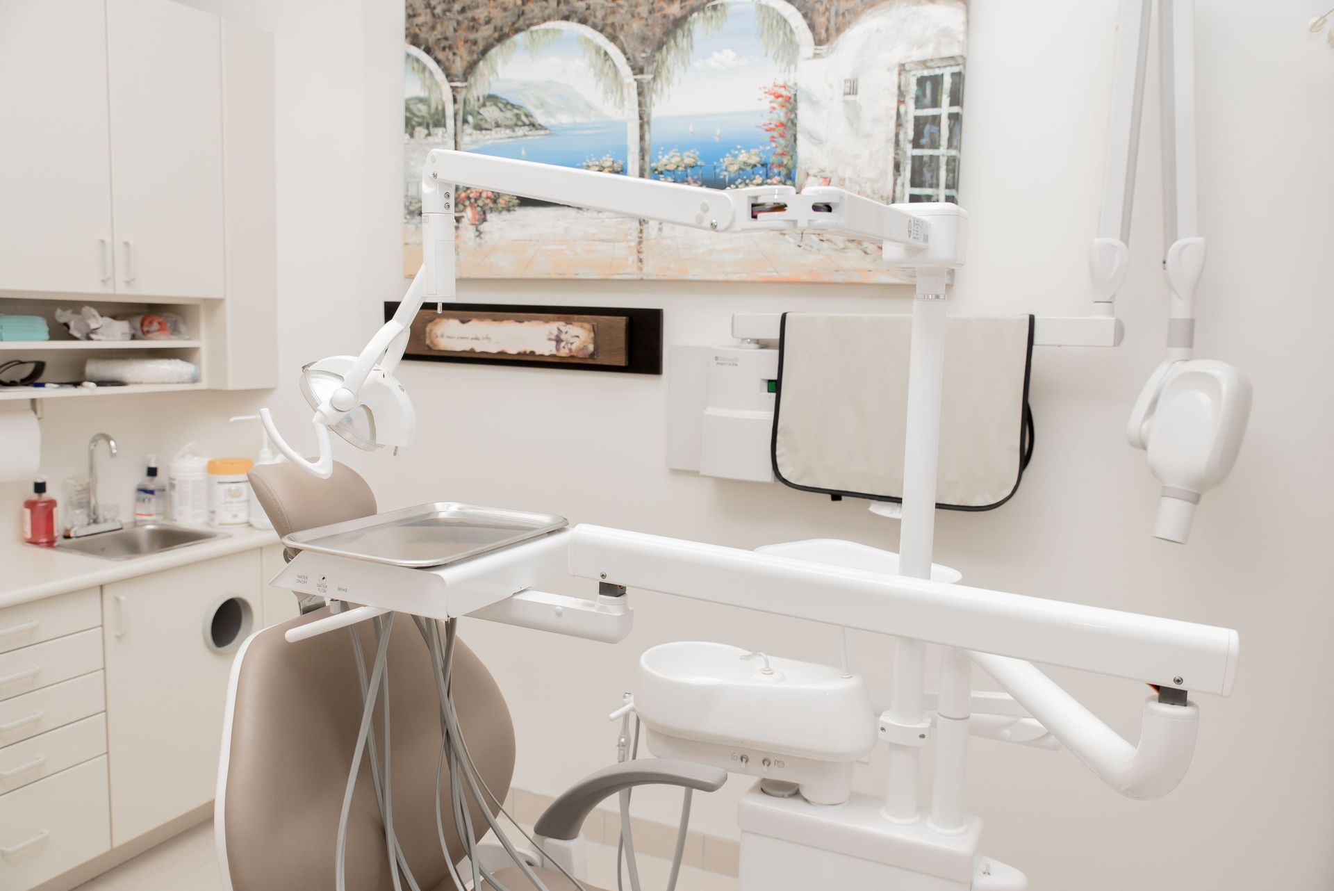 A dental office with a dental chair and a sink.