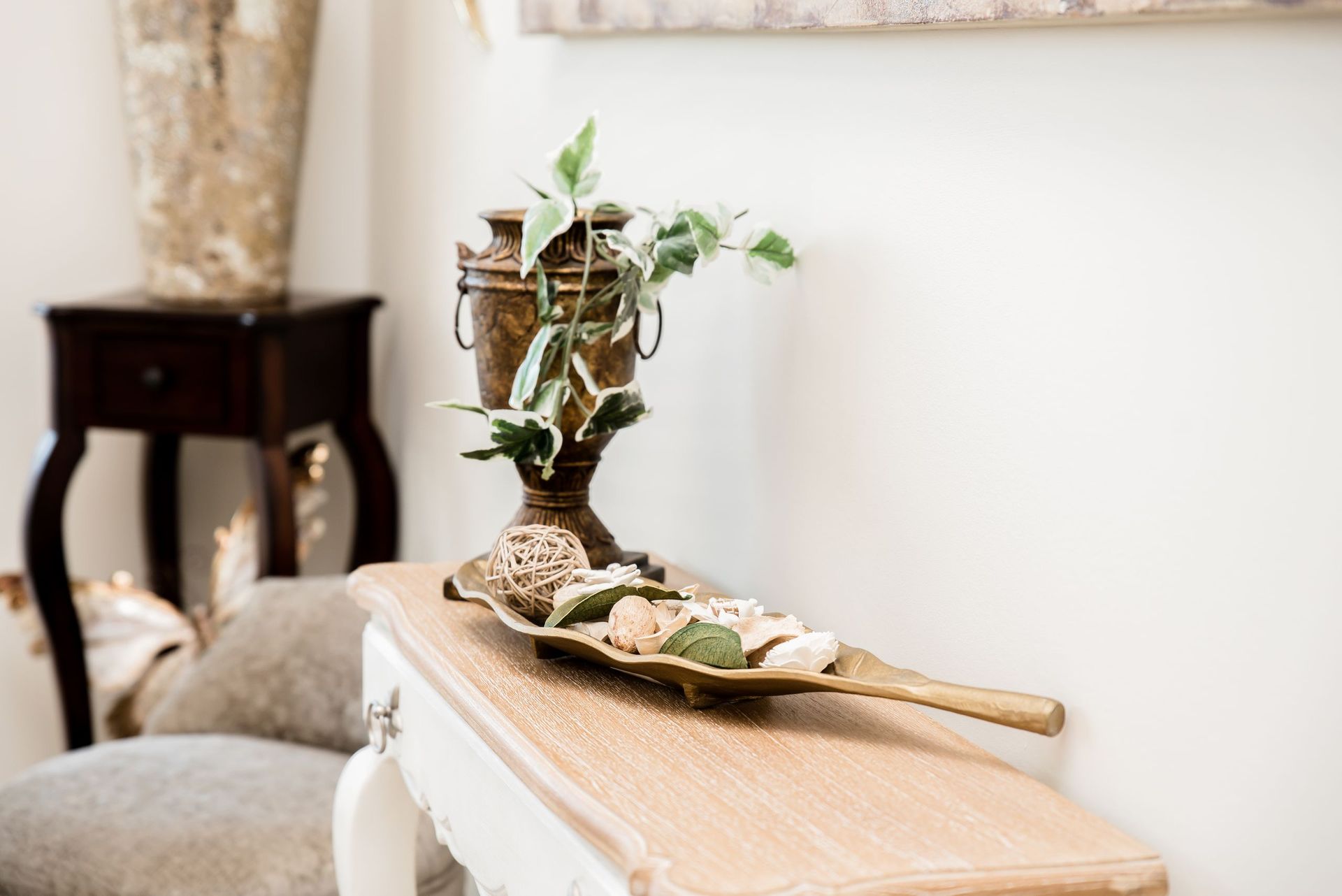 A table with a vase and a plant on it.