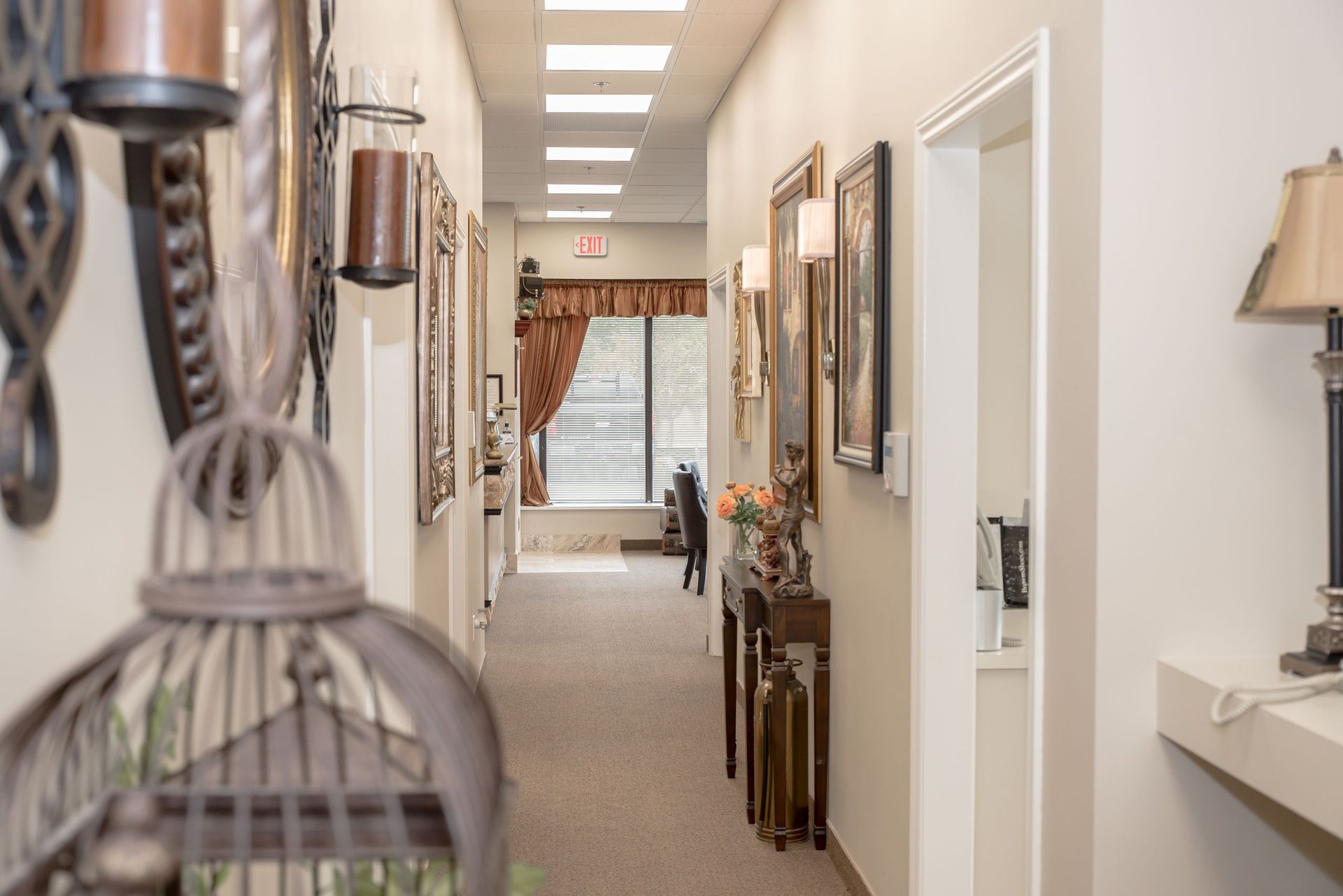 A long hallway with a bird cage in the middle of it.
