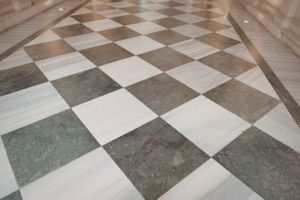 Black-and-white checkered marble floor in a hallway with stone walls