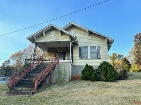 A small house with stairs leading up to the front of it.