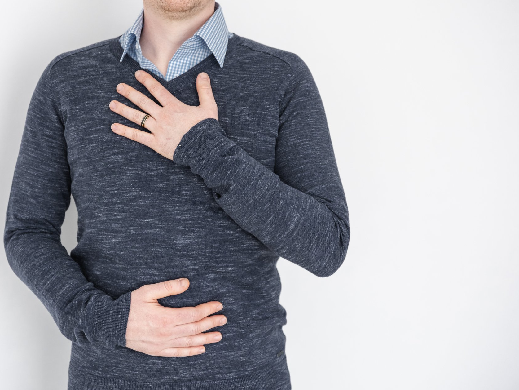 Een man in een blauwe trui houdt zijn handen tegen zijn borst. Chris Gieling Coaching en Training