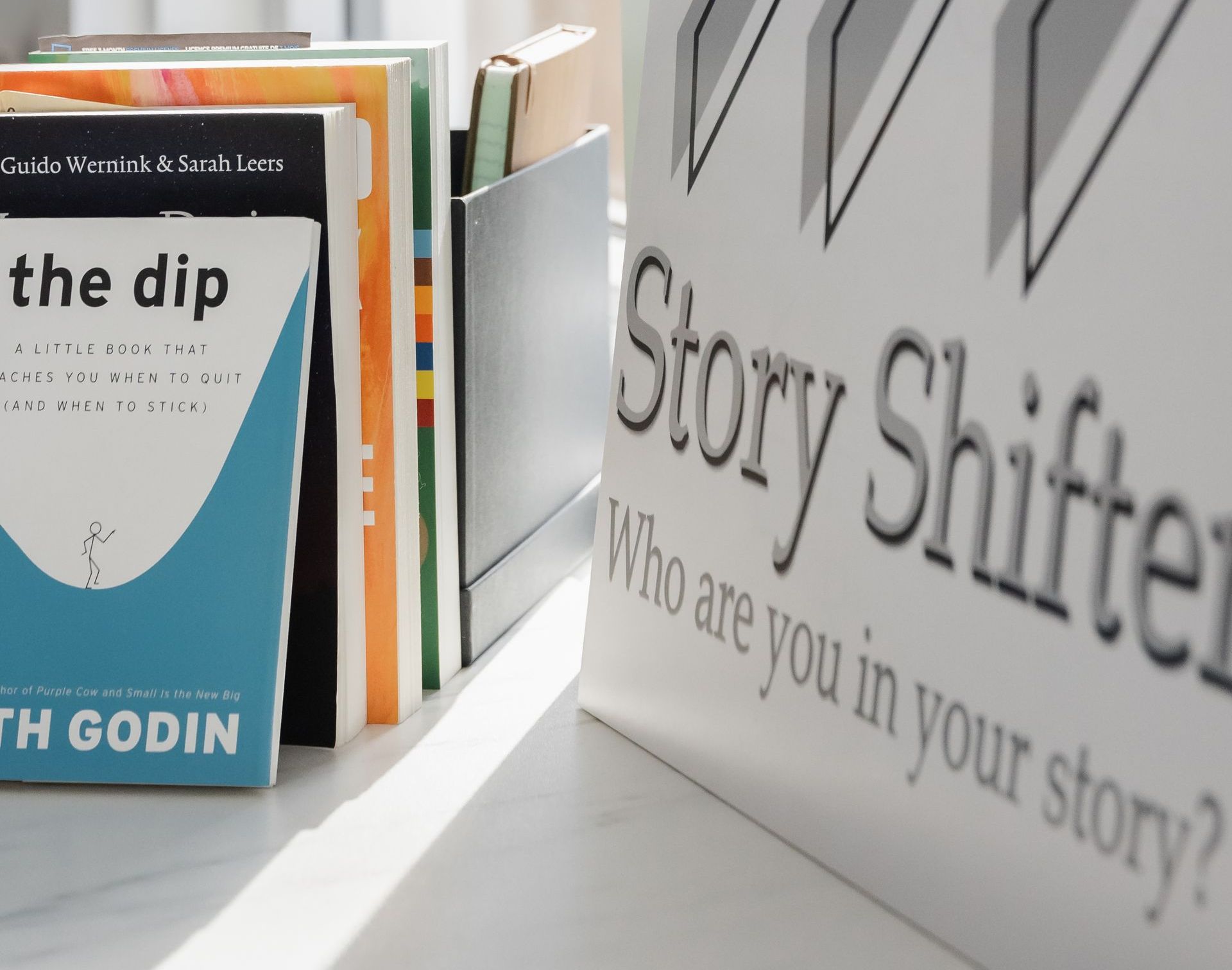 Een boek met de naam The Dip ligt naast een bord met de tekst Story Shifter