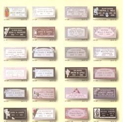 A grid of various rectangular gravestone plaques, each with engraved names and dates.