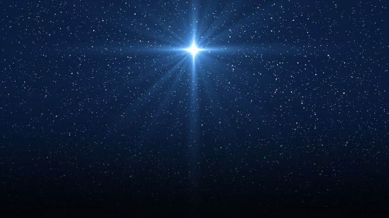 Bright blue star shining in a dark blue starry night sky.