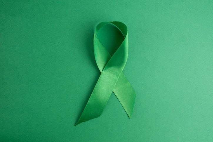 A A green ribbon lying on a green background.