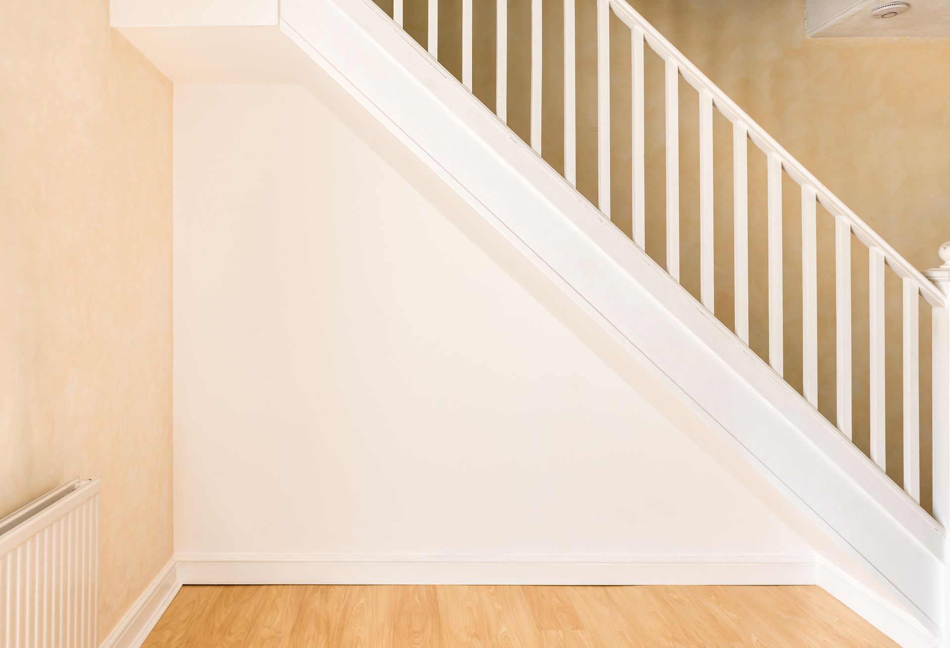 Une pièce vide avec des escaliers et une rampe blanche