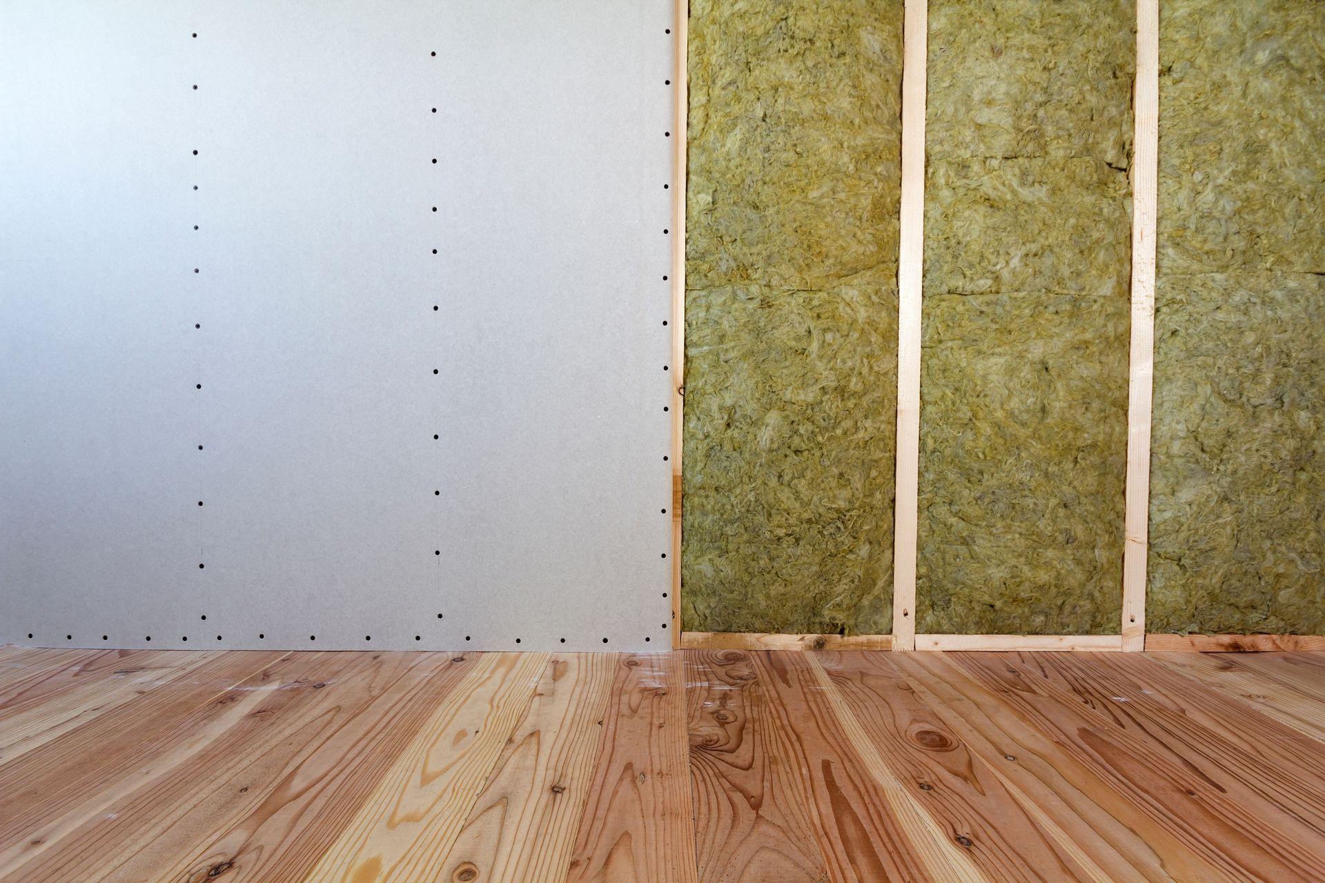 Une pièce avec un plancher en bois et un mur avec isolation.