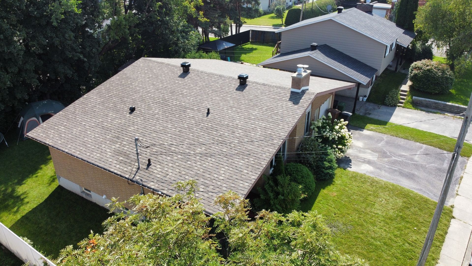 Une vue aérienne d'une maison avec un toit dans un quartier résidentiel.