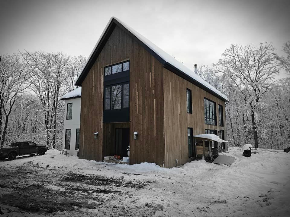 Une photo en noir et blanc d'une maison recouverte de neige.