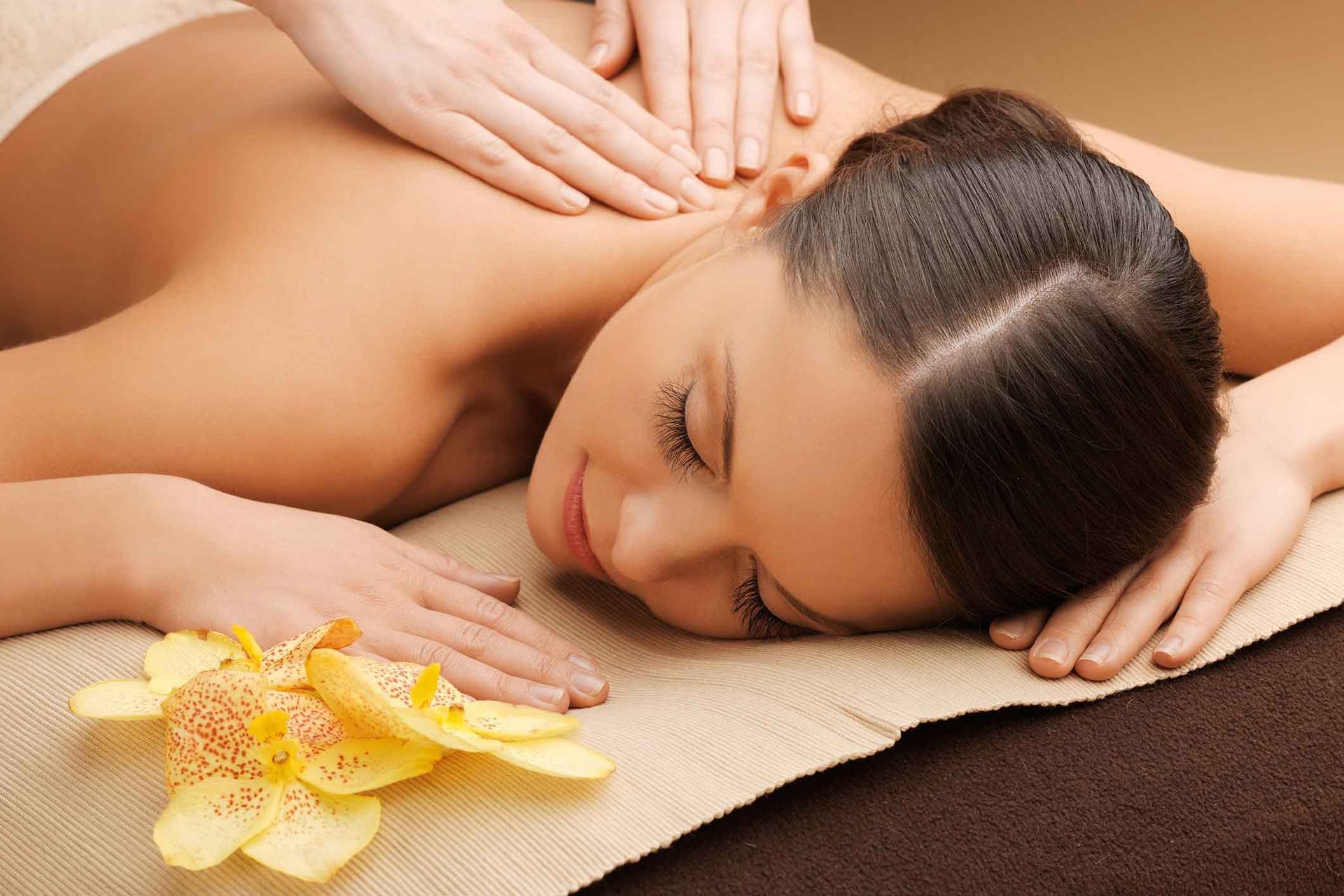 A Woman Is Laying On A Towel Getting A Massage – Coral Springs, FL - Life In Motion Bodyworks and Aesthetics