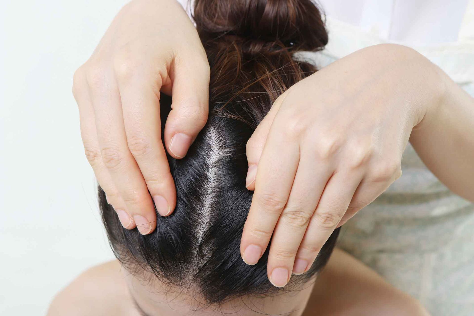 A Woman Is Holding Her Hair In A Bun With Her Hands – Coral Springs, FL - Life In Motion Bodyworks and Aesthetics