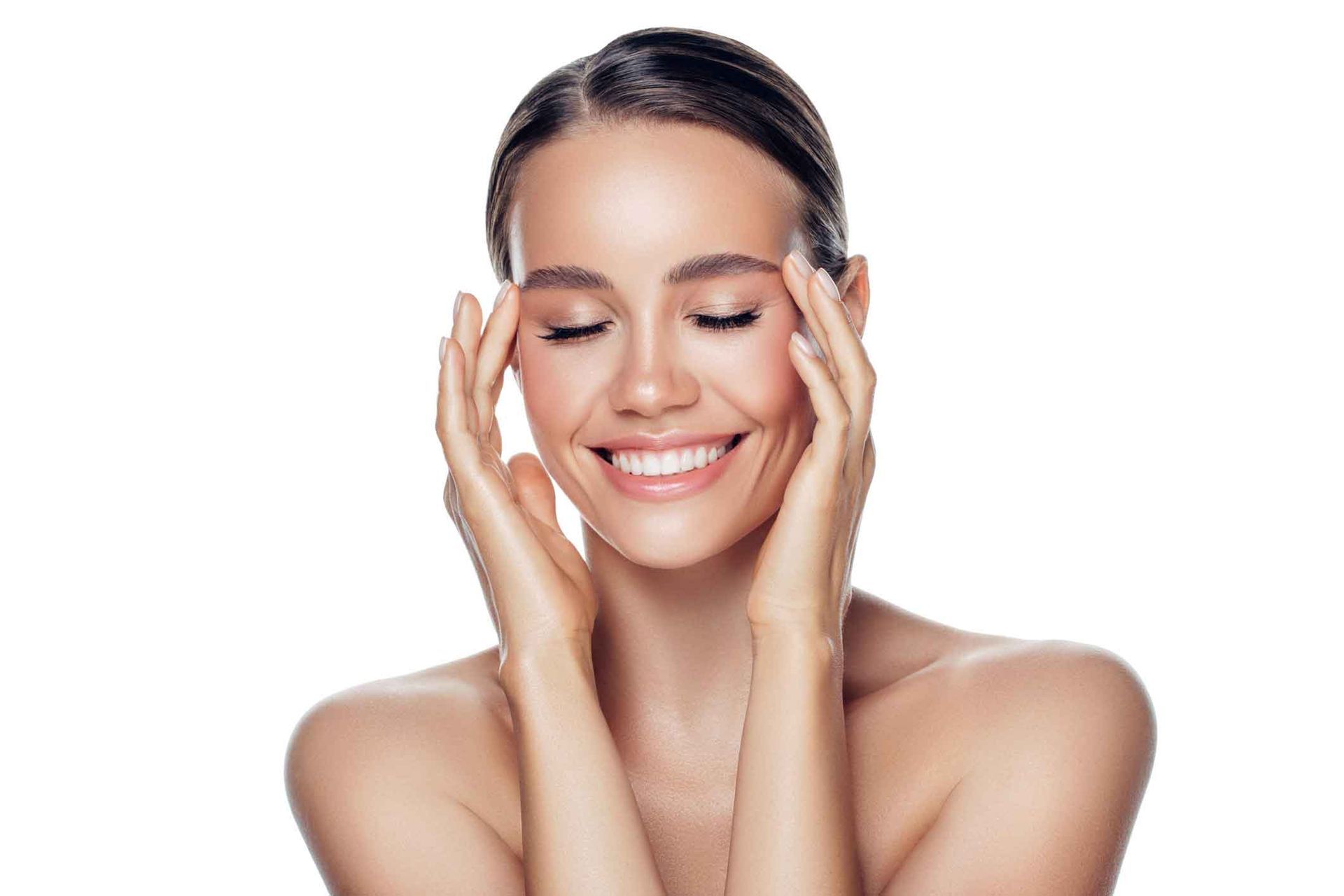 A Woman Is Smiling And Touching Her Face With Her Hands – Coral Springs, FL - Life In Motion Bodyworks and Aesthetics