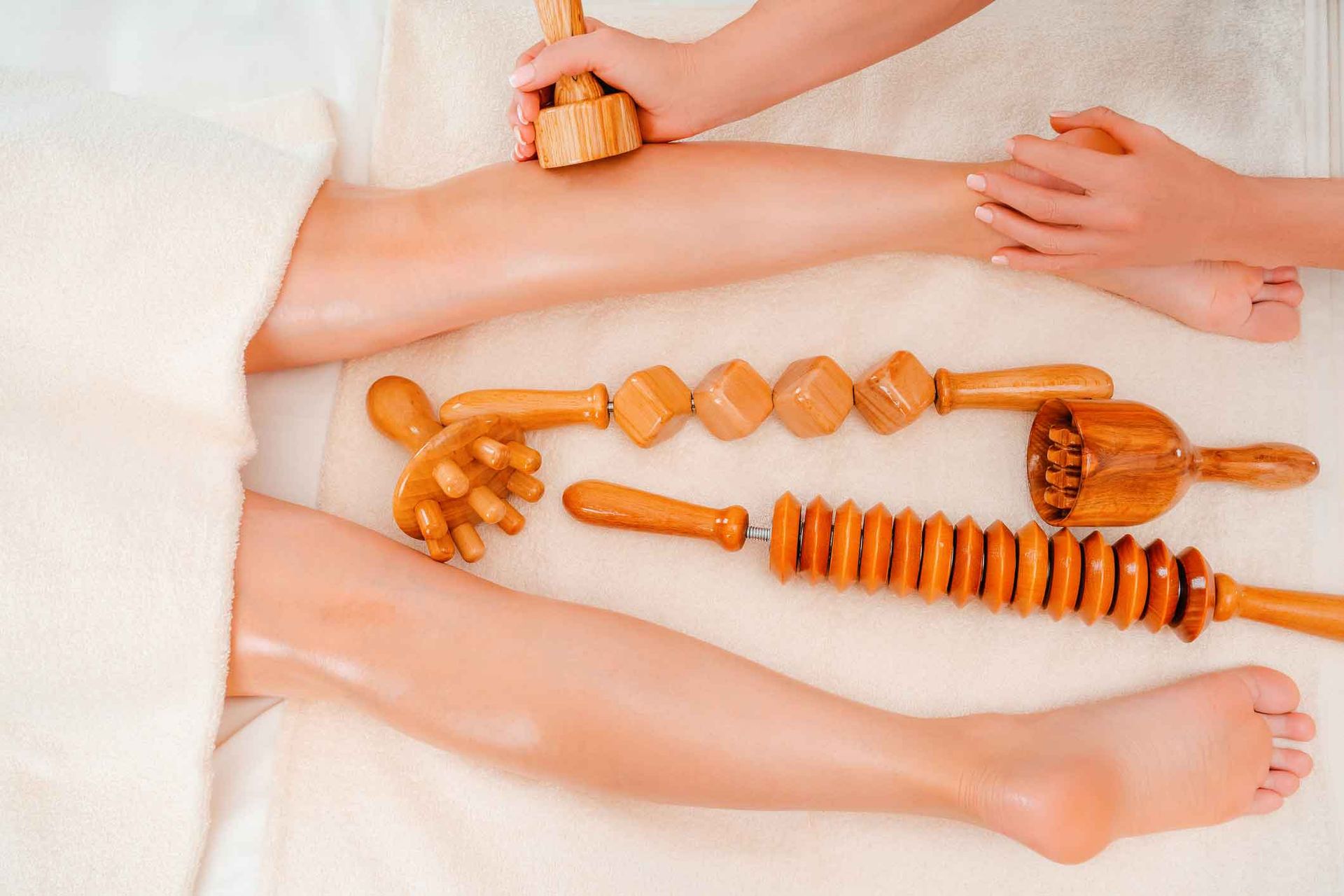 A Woman Is Getting A Wooden Massage On Her Legs – Coral Springs, FL - Life In Motion Bodyworks and Aesthetics