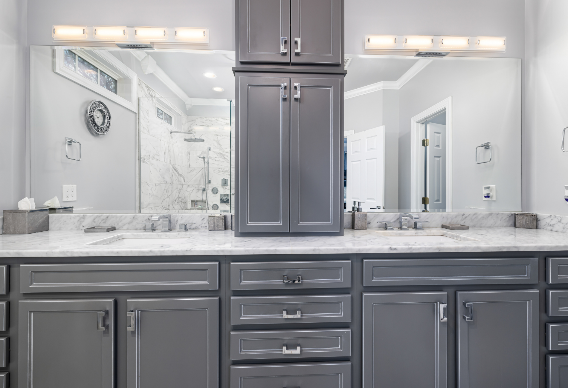 Gray bathroom with double sinks, matching cabinets, and large mirrors.