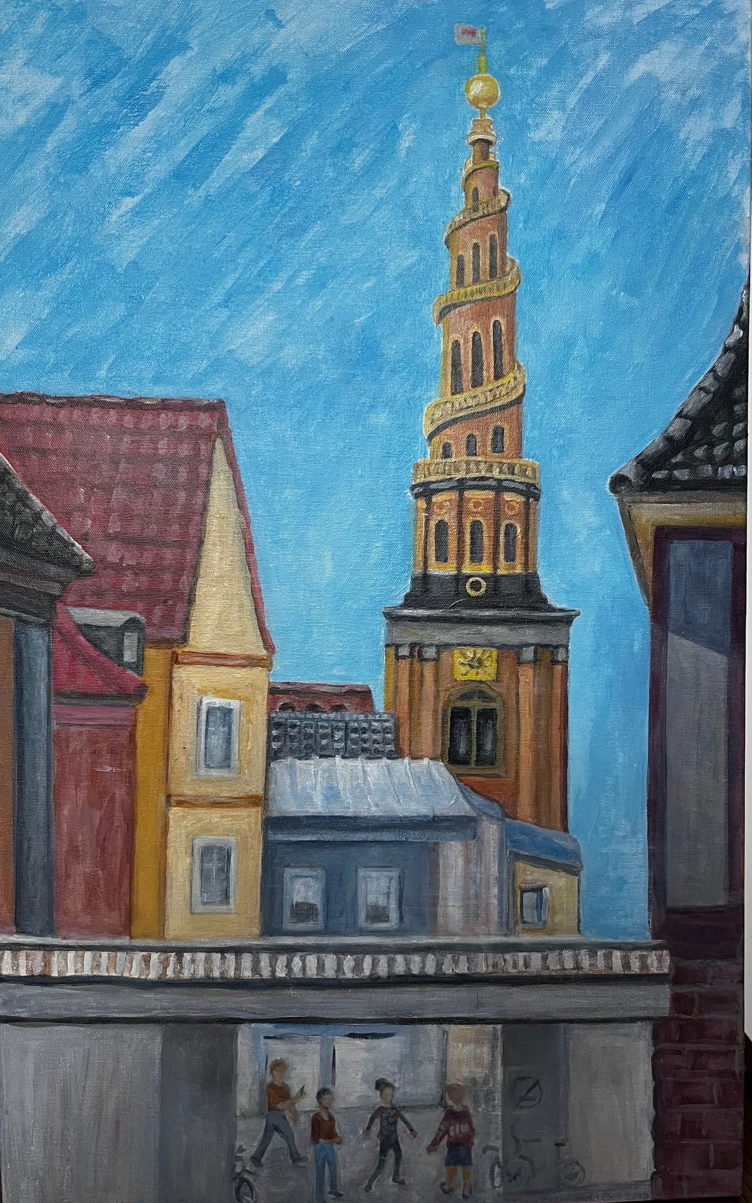 Street scene with tall church tower, colorful buildings, and people walking under a cloudy blue sky