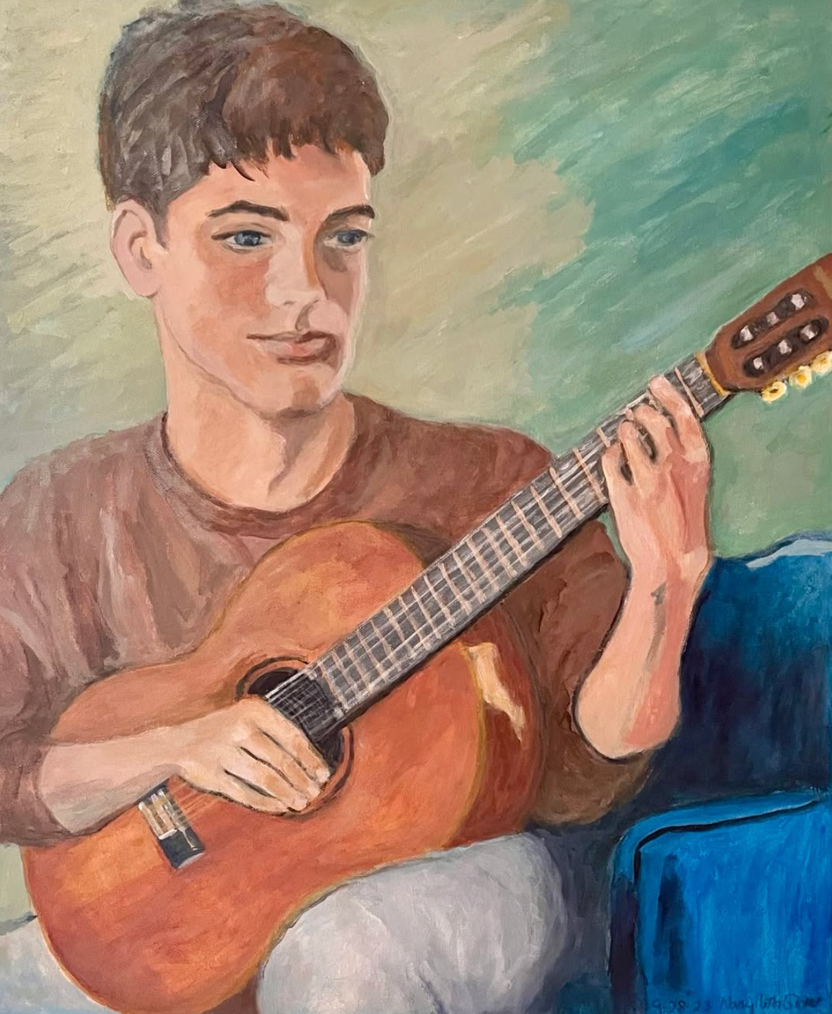 Person playing a classical guitar on a couch, with a soft green background.