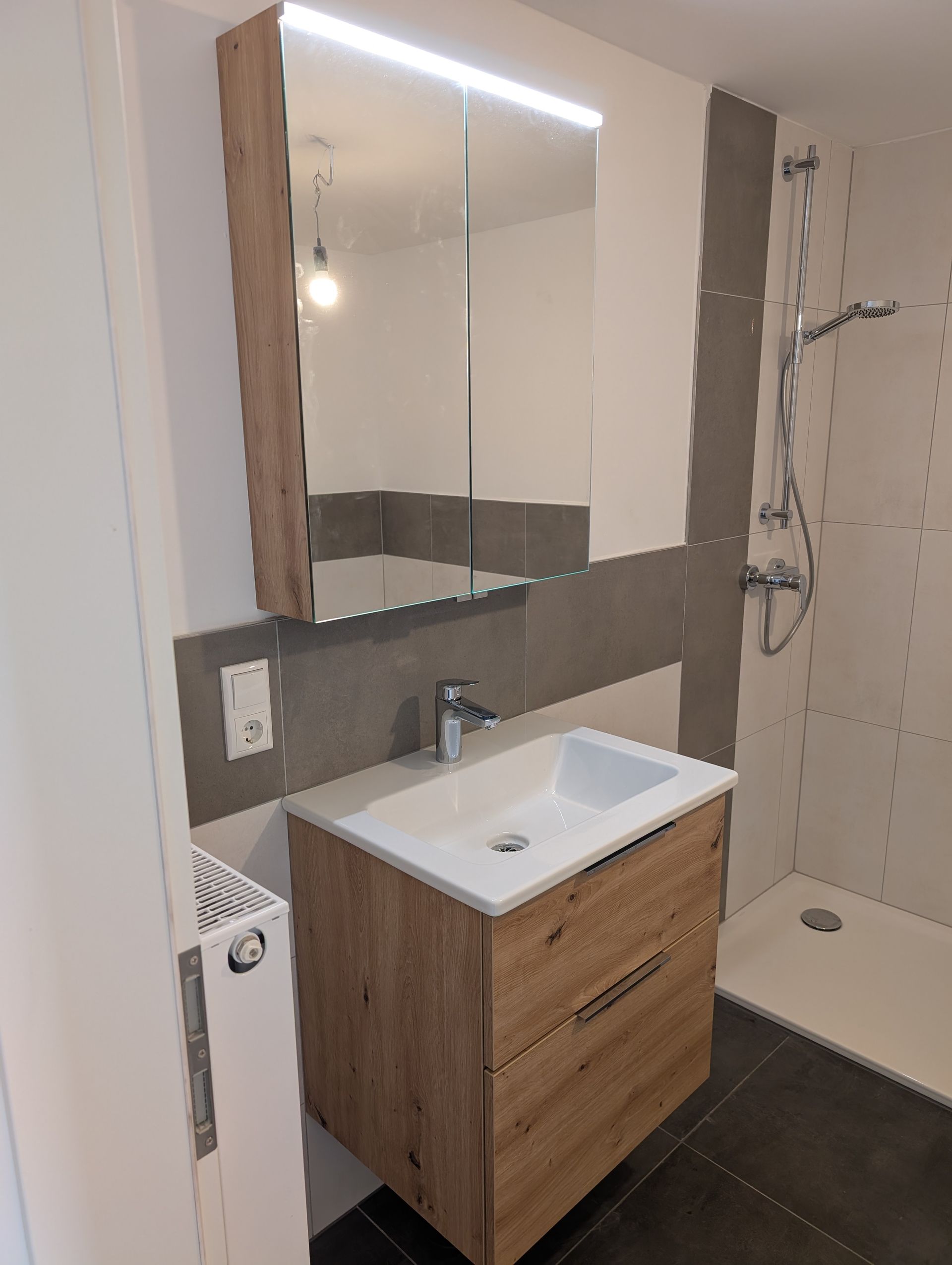 Ein Badezimmer mit Waschbecken, Spiegel und Dusche.