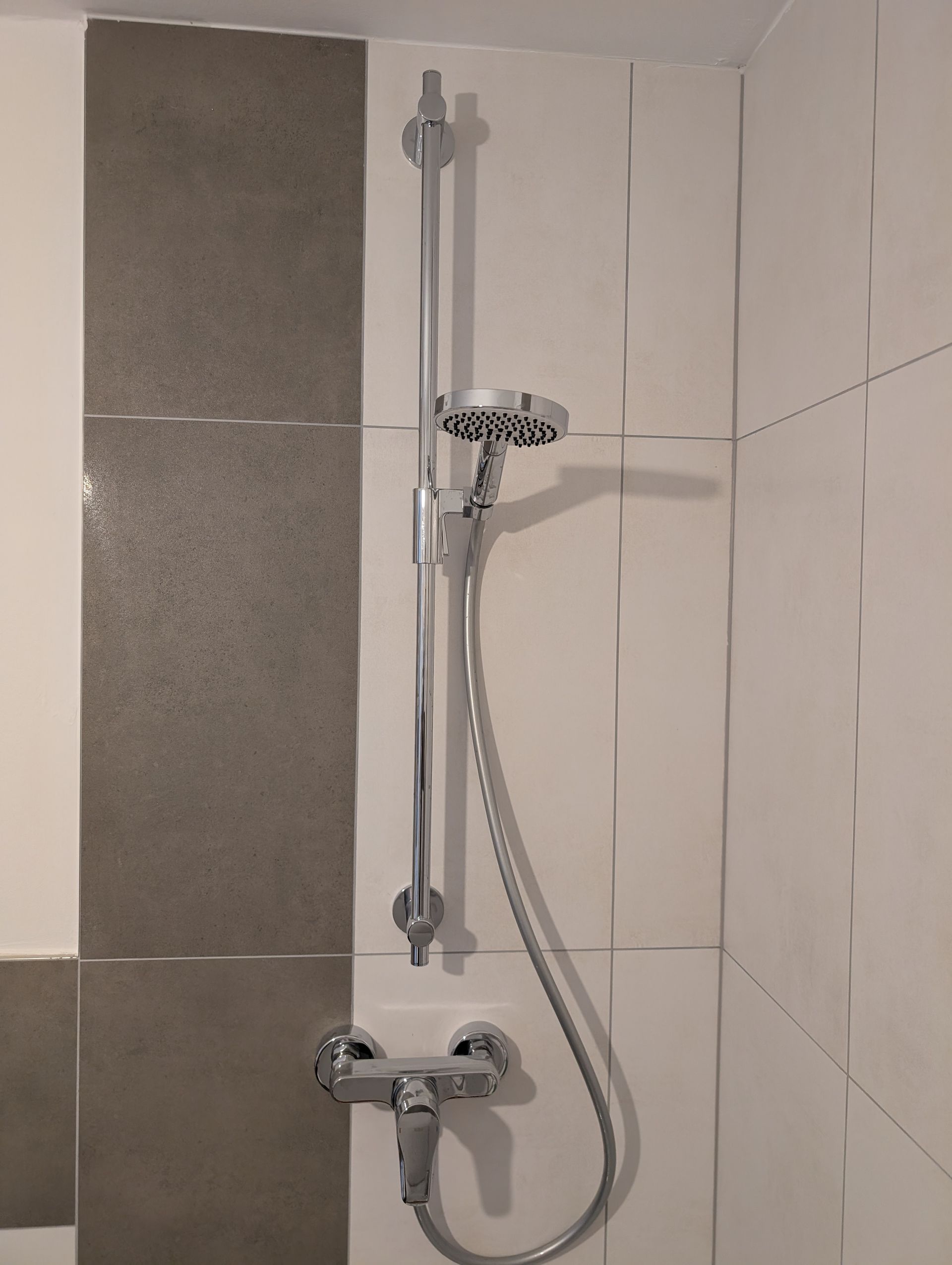 Ein Duschkopf mit einem daran befestigten Schlauch in einem Badezimmer.