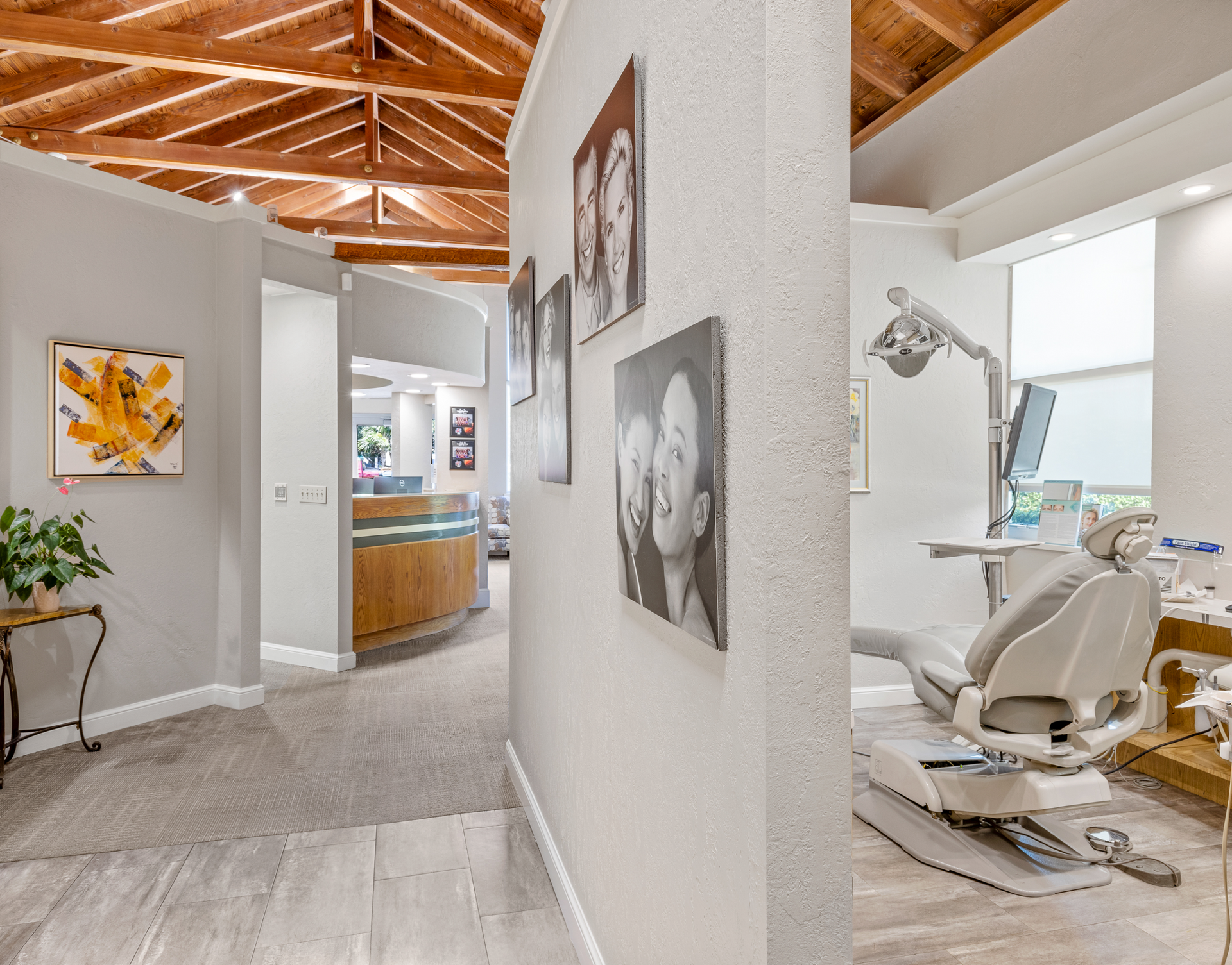 A dental office with a dental chair and paintings on the wall.